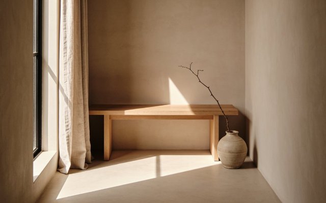 A timber bench beside a linen curtain in a quiet clinic hallway